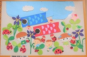 青空。こいのぼり。野原には、菖蒲の花、てんとうむし、笑顔のこどもたち。5月の壁面飾りです。