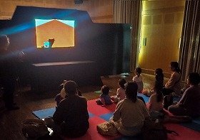 写真1 　手影絵を見ている参加者。