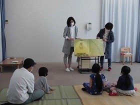 大型絵本の読み聞かせを聞いている子どもたち