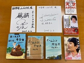 麒麟の田村裕さん、ソラシドの本坊元児さんのサイン、田村裕さん関連の図書館所蔵資料、寄贈いただいた3冊の本。