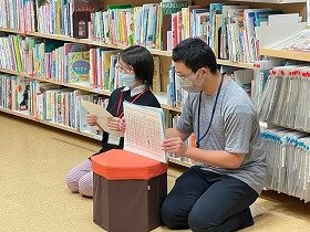 YAサポーターの2人が手作りの紙芝居を読んでいる様子の画像