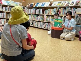 子供に向かって手作りの紙芝居の読み聞かせを行っている様子。